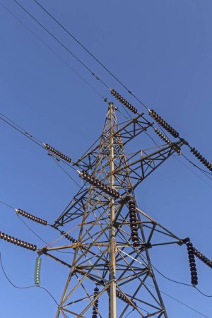 Foto de Primer plano de los cables y el pilón de electricidad contra el cielo azul - Imagen libre de derechos