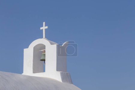 Téléchargez les photos : Clocher sur la chapelle sur l'île de Santorin en Grèce contre un ciel bleu clair - en image libre de droit