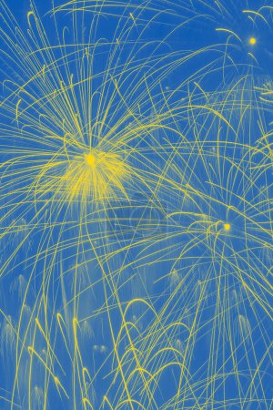 Téléchargez les photos : Fond de vacances lumineux : feux d'artifice abstraits dans le ciel coloré aux couleurs du drapeau ukrainien - en image libre de droit