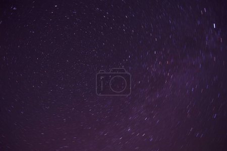 Foto de Fondo natural abstracto: pistas de estrellas alrededor de la estrella polar en el cielo oscuro de la noche - Imagen libre de derechos