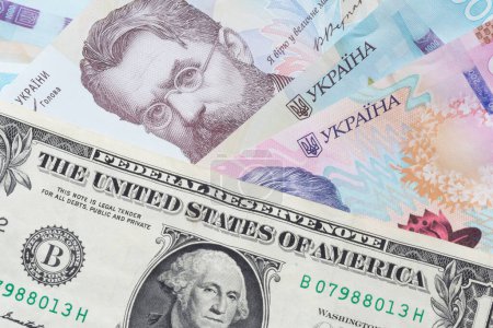 Foto de Primer plano de un billete en dólares de los Estados Unidos que se encuentra en billetes de hrivnya ucranianos - Imagen libre de derechos