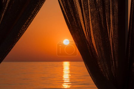 Photo for View on sunrise behind curtains in resort - Royalty Free Image