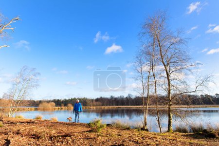 Photo for Man with his dog at Lake in Dutch Leersummer veld - Royalty Free Image