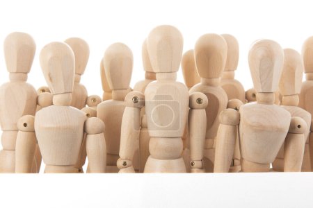 Photo for Many wooden mannequins behind board  isolated over white - Royalty Free Image