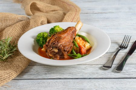 Lamb Shank is a tender, slow-cooked dish featuring a lamb leg portion braised with herbs and vegetables until the meat is succulent and falls off the bone. 