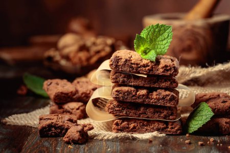 Téléchargez les photos : Pieces of fresh brownie with mint on a wooden table. - en image libre de droit