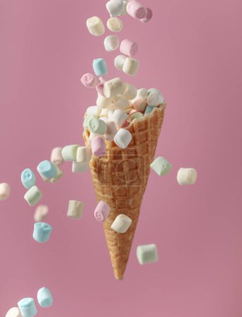 Photo for Small colorful marshmallows fall in a waffle cone. - Royalty Free Image