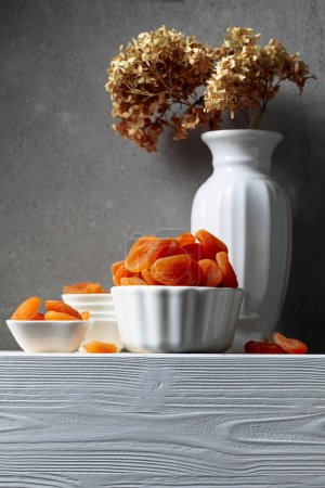 Téléchargez les photos : Abricots secs sur une table en bois blanc. Espace de copie. - en image libre de droit
