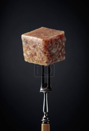 Photo for The square piece of headcheese on a fork. - Royalty Free Image