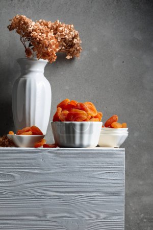 Téléchargez les photos : Abricots secs sur une table en bois blanc. Espace de copie. - en image libre de droit