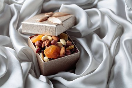 Photo for Dried fruits and nuts in a gift box on a grey cloth. - Royalty Free Image