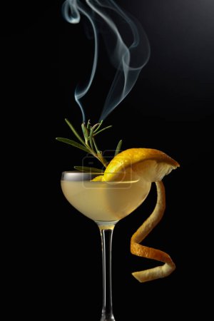 Photo for Limoncello in a glass. A sweet Italian lemon liqueur, a traditional strong alcoholic drink garnished with a steaming rosemary branch. - Royalty Free Image