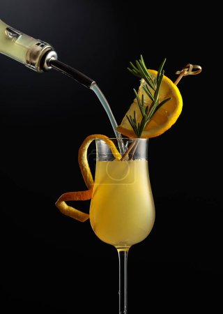 Limoncello en vaso, licor de limón italiano dulce, bebida alcohólica fuerte tradicional adornada con rodajas de limón y romero.