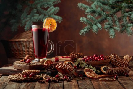 Foto de Bebida caliente de Navidad con especias, cítricos secos y arándanos en una vieja mesa de madera. Copiar espacio. - Imagen libre de derechos