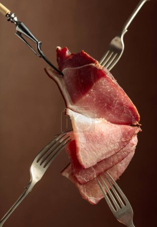 Photo for Dry-cured pork fillet on a brown background. - Royalty Free Image