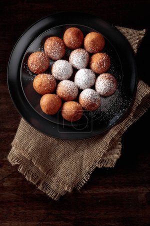 Foto de Balls of freshly baked homemade cottage cheese doughnuts sprinkled with sugar powder. Top view. - Imagen libre de derechos