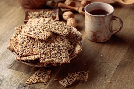 Foto de Crispy crackers with sunflower seeds and flax seeds on a wooden table. - Imagen libre de derechos