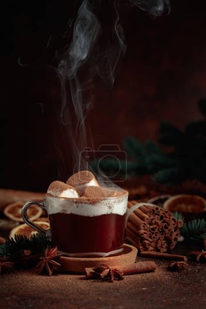 Foto de Chocolate caliente de Navidad con malvaviscos salpicados con cacao en polvo. Bebida de invierno fotografía sobre un fondo marrón oscuro. - Imagen libre de derechos