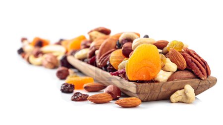 Téléchargez les photos : Mélange de noix et de fruits secs isolés sur un fond blanc. Abricots, raisins secs, noix, noisettes, noix de cajou, pacanes et amandes présentés. - en image libre de droit