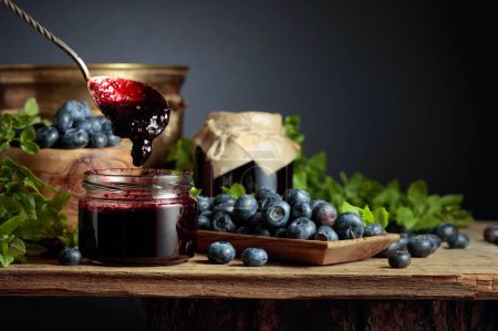Photo for Blueberry jam with fresh berries on an old wooden table. Copy space. - Royalty Free Image