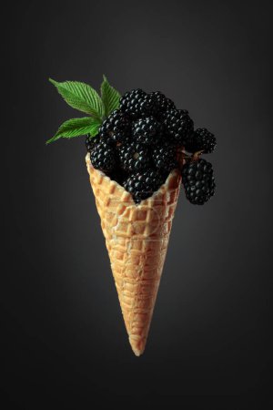 Photo for Fresh blackberries in a waffle cone on a dark background. - Royalty Free Image