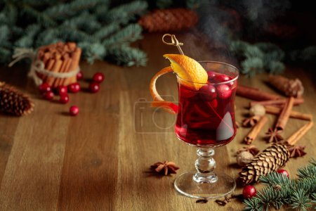 Téléchargez les photos : Boisson chaude de Noël aux épices, à l'orange et aux canneberges sur une vieille table en bois. - en image libre de droit