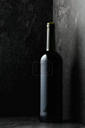Foto de Botella de vino tinto sobre fondo de piedra negra. - Imagen libre de derechos