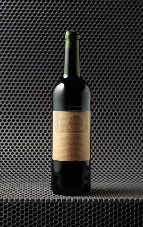 Photo for Bottle of red wine on a grey cellular background. On a bottle old empty label. - Royalty Free Image