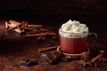 Photo for Hot chocolate with whipped cream. Hot chocolate with ingredients on a brown table. - Royalty Free Image