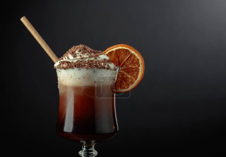 Téléchargez les photos : Cocktail au chocolat avec crème fouettée saupoudrée de pépites de chocolat et garnie d'une tranche d'orange séchée. Espace de copie. - en image libre de droit