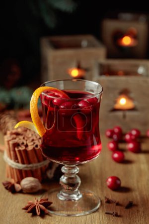 Foto de Bebida de Navidad con especias y arándanos en una vieja mesa de madera. - Imagen libre de derechos