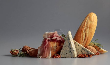 Foto de Prosciutto con queso azul, baguette, nueces y tomillo. Snacks tradicionales mediterráneos. - Imagen libre de derechos