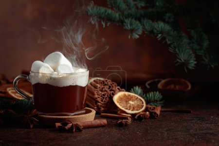 Foto de Chocolate caliente de Navidad con malvaviscos. Bebida de invierno con especias sobre un fondo marrón oscuro. - Imagen libre de derechos