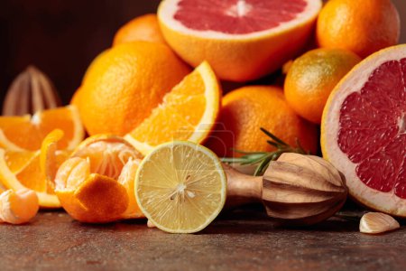 Foto de Cítricos sobre una vieja mesa marrón. Se presentan naranjas, pomelos, limones y mandarinas. - Imagen libre de derechos