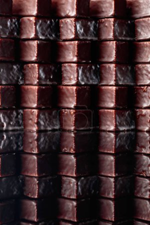 Téléchargez les photos : Bonbons au chocolat sur un fond réfléchissant noir. - en image libre de droit