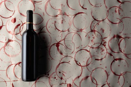 Foto de Botella de vino tinto sobre fondo con manchas de vino. Copiar espacio. - Imagen libre de derechos