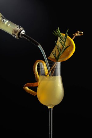Photo for Limoncello in glass, sweet Italian lemon liqueur, traditional strong alcoholic drink garnished with lemon slice and rosemary. - Royalty Free Image