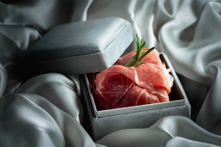 Photo for Prosciutto with rosemary in a gray gift box. Concept of the theme of expensive food. - Royalty Free Image