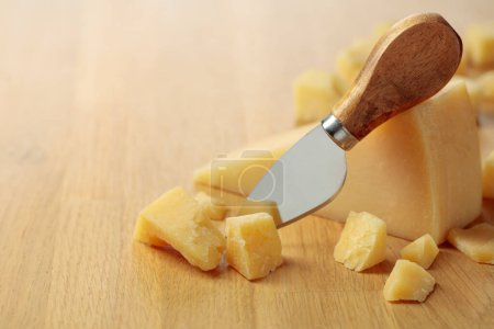 Foto de Parmesan cheese and knife on a wooden cutting board. - Imagen libre de derechos