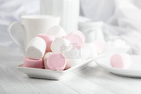 Photo for Pink and white marshmallows on a wooden table with kitchen utensils. - Royalty Free Image