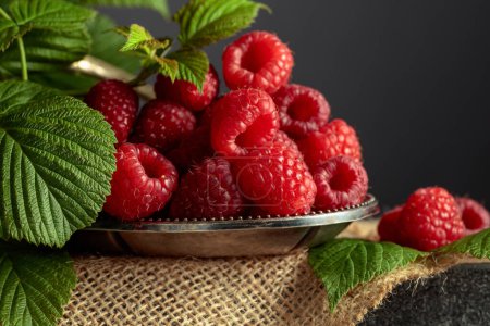 Foto de Ripe juicy raspberries in a small metal dish. Copy space. - Imagen libre de derechos