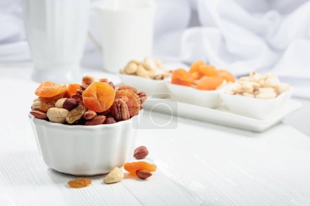 Foto de Frutas secas y frutos secos surtidos sobre una mesa de madera blanca. - Imagen libre de derechos