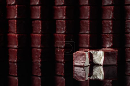 Photo for Chocolate candies with milk souffle on a black reflective background. - Royalty Free Image