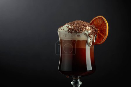 Téléchargez les photos : Cocktail au chocolat avec crème fouettée saupoudrée de pépites de chocolat et garnie d'une tranche d'orange séchée. Espace de copie. - en image libre de droit