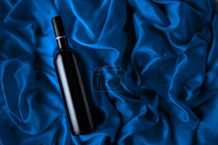 Foto de Bottle of red wine on a satin background. Top view. - Imagen libre de derechos