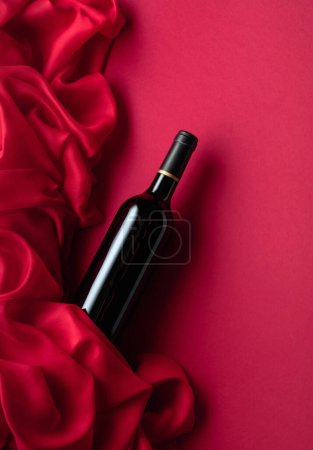 Foto de Botella de vino tinto sobre fondo tinto. Vista superior. - Imagen libre de derechos