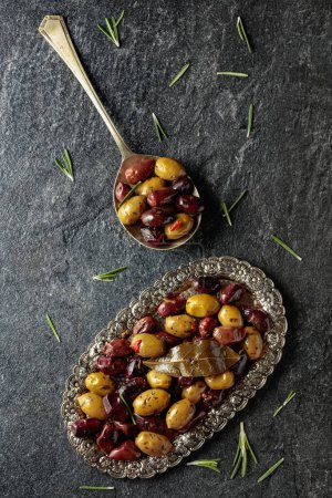 Téléchargez les photos : Spicy olives on a black stone table. Top view. - en image libre de droit