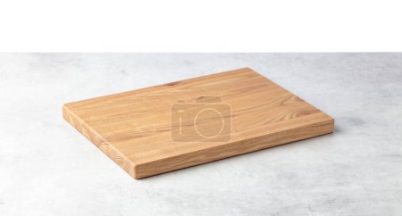 Foto de Cutting board on a grey stone table. Isolated on a white background. Culinary background. Empty wooden cutting board, product display space. - Imagen libre de derechos