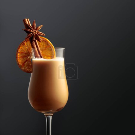 Téléchargez les photos : A glass of Irish cream coffee liqueur with cinnamon, anise, and a dried orange slice. Copy space. - en image libre de droit