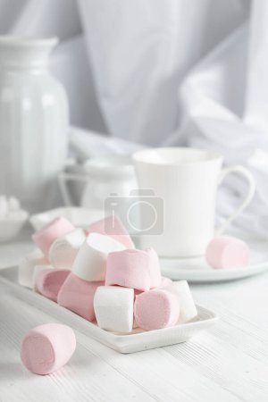 Photo for Pink and white marshmallows on a wooden table with kitchen utensils. - Royalty Free Image